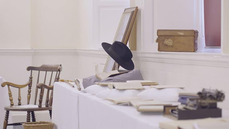 Some of the items in the G.K. Chesterton collection, including a hat, chair, and books and documents.